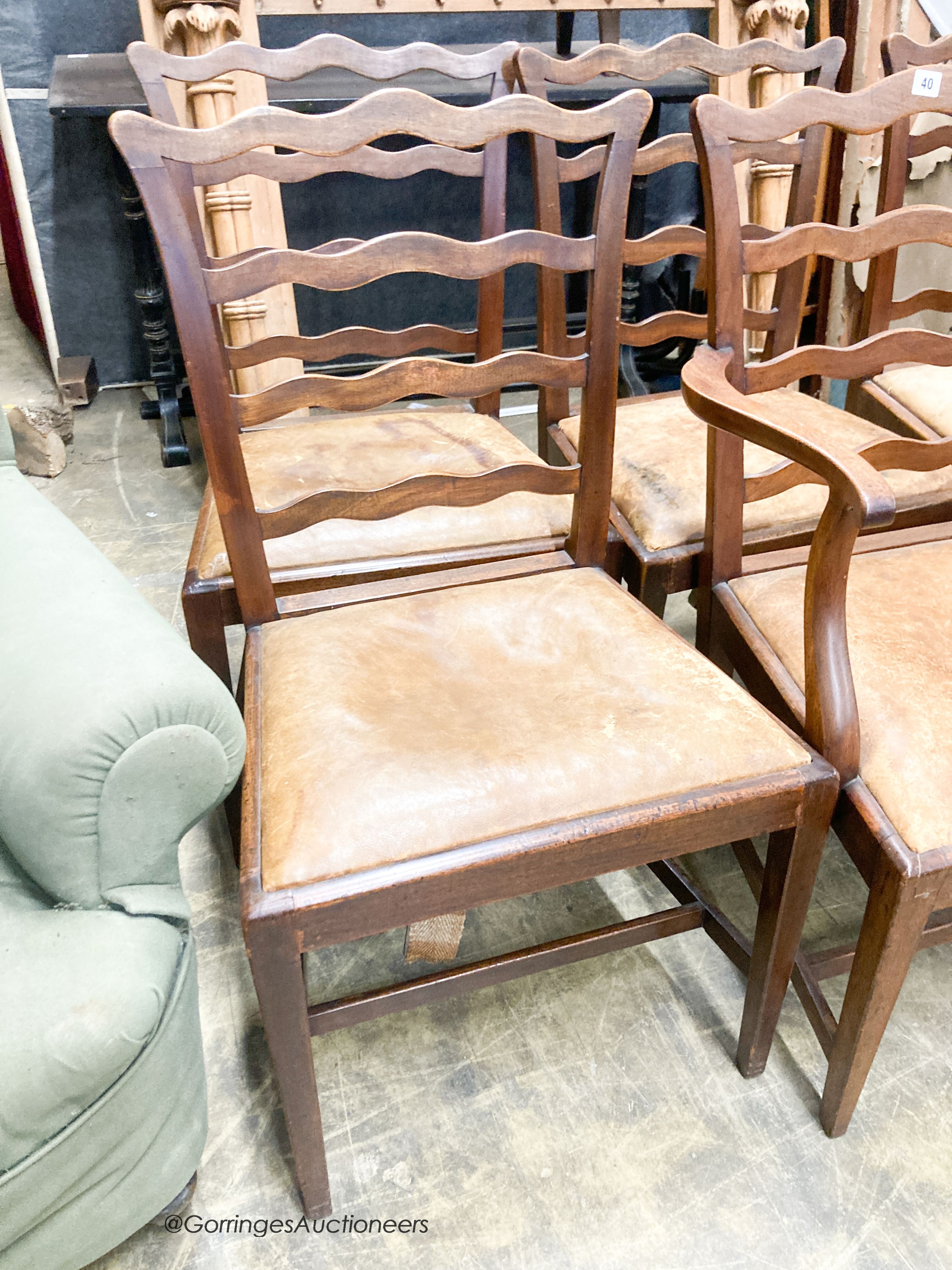 A set of six George III mahogany ladderback dining chairs with leather drop in seats (one with arms)